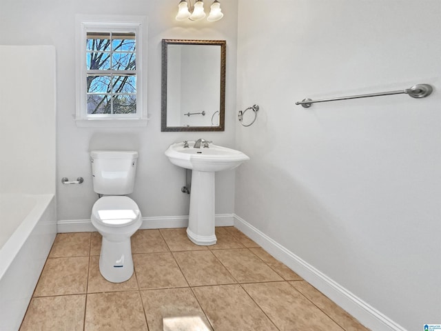 full bathroom with tile patterned flooring, toilet, baseboards, and a bathing tub