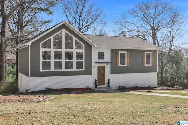 view of front facade with a front yard and brick siding