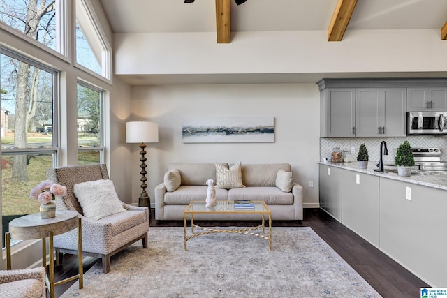 living room with beamed ceiling, ceiling fan, and dark wood-style flooring