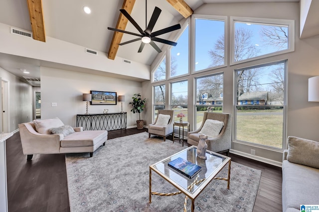 living area with visible vents, beamed ceiling, and wood finished floors