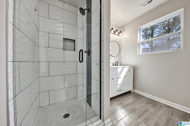 full bath with visible vents, baseboards, a stall shower, and vanity