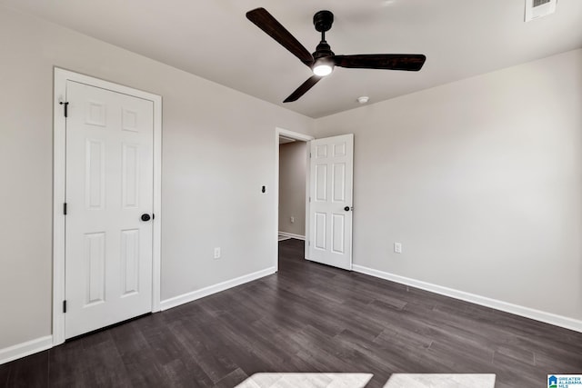 unfurnished bedroom with dark wood-style floors, baseboards, visible vents, and ceiling fan