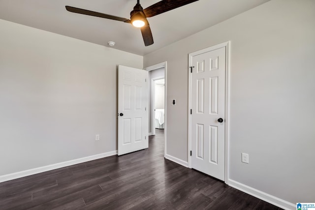 unfurnished bedroom with baseboards, ceiling fan, and dark wood-style flooring