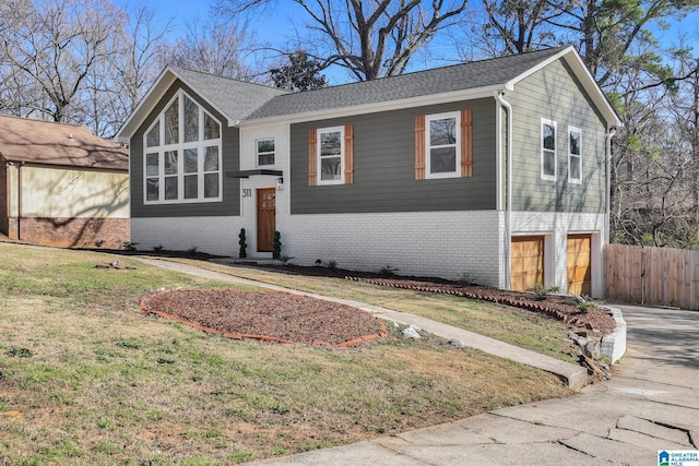 view of front of home featuring concrete driveway, fence, brick siding, and a front yard