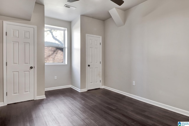 unfurnished bedroom featuring dark wood finished floors, visible vents, and baseboards