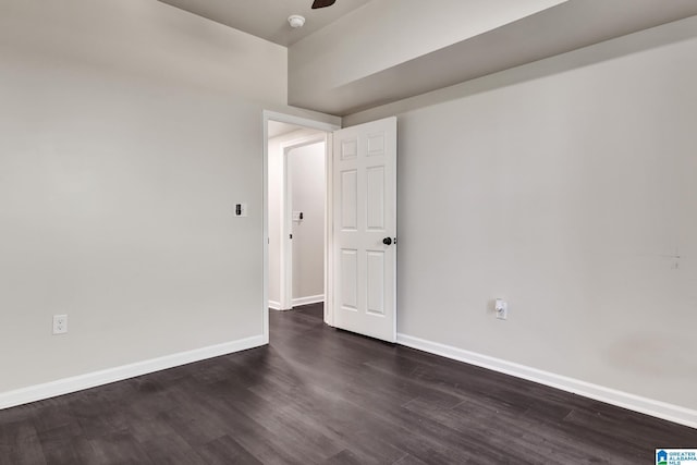 unfurnished room featuring a ceiling fan, dark wood-style floors, and baseboards