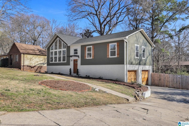 view of front of property with brick siding, fence, concrete driveway, a front yard, and a garage