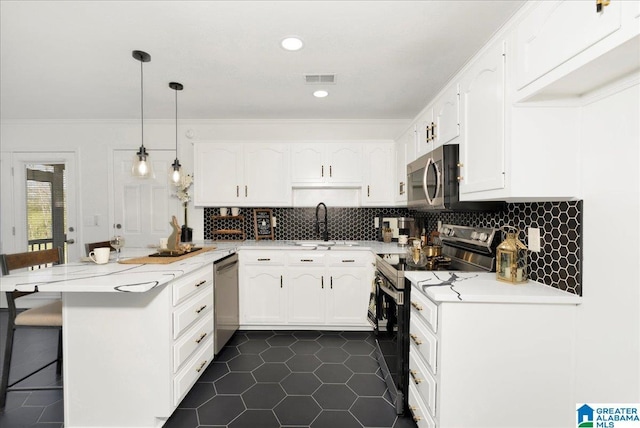 kitchen featuring a kitchen breakfast bar, appliances with stainless steel finishes, a peninsula, white cabinets, and a sink