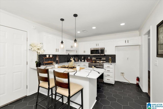 kitchen featuring ornamental molding, a peninsula, white cabinets, stainless steel appliances, and dark tile patterned flooring