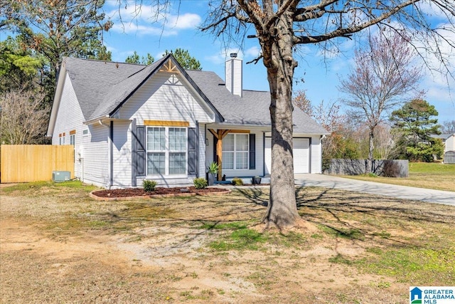 view of front of property with driveway, fence, a front yard, an attached garage, and a chimney