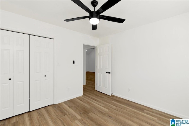 unfurnished bedroom featuring a closet, a ceiling fan, light wood-type flooring, and baseboards