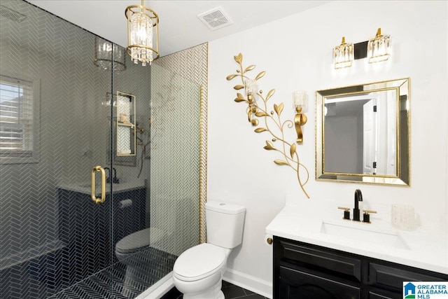 bathroom with vanity, baseboards, visible vents, a stall shower, and toilet