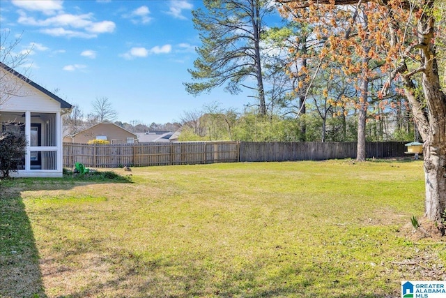 view of yard with a fenced backyard and a sunroom