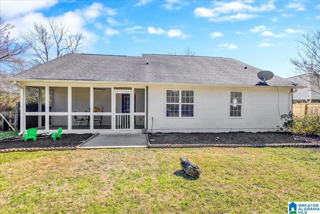 back of property featuring fence, roof with shingles, a yard, and a sunroom