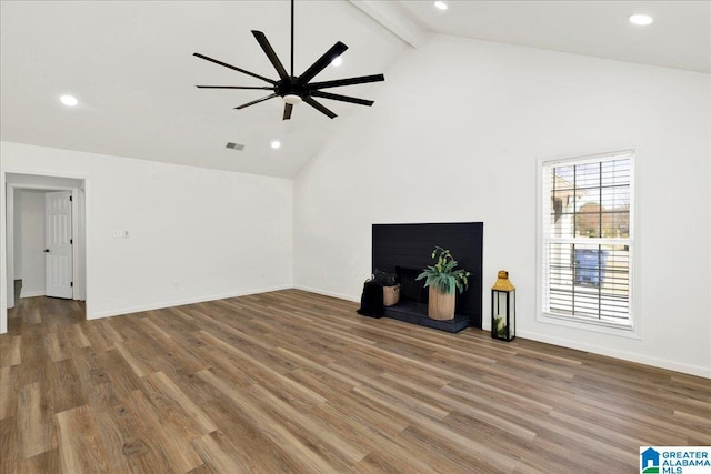 unfurnished living room with visible vents, beamed ceiling, baseboards, and wood finished floors