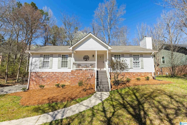 ranch-style home with stairway, covered porch, a chimney, a front lawn, and brick siding