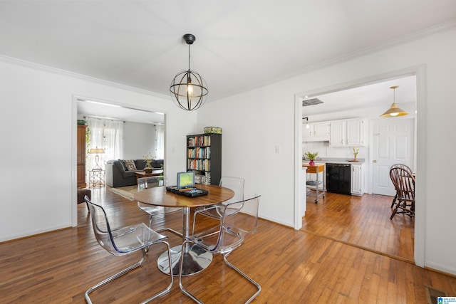 dining area featuring crown molding, visible vents, baseboards, and light wood finished floors