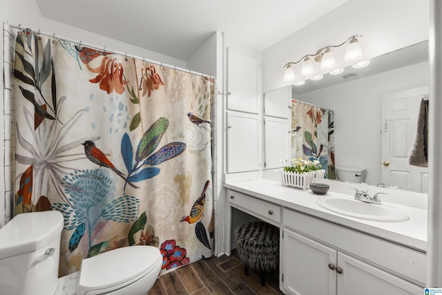 bathroom with wood finish floors, toilet, and vanity