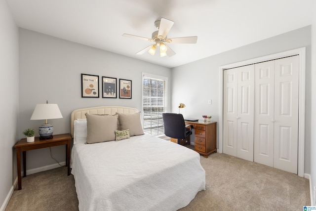 carpeted bedroom with a closet, baseboards, and ceiling fan