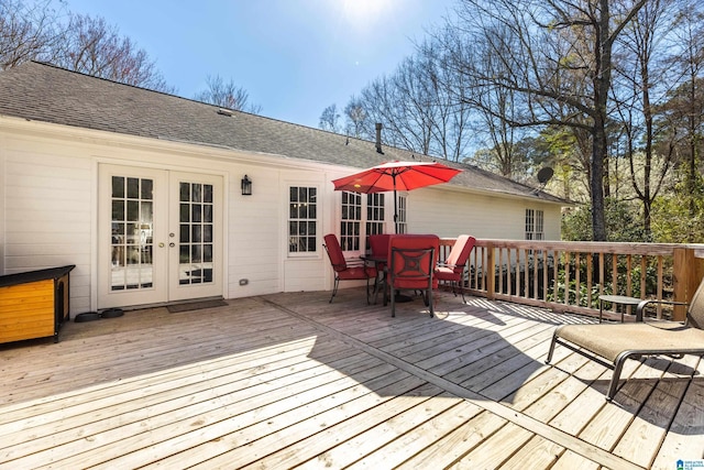 wooden terrace with outdoor dining space and french doors