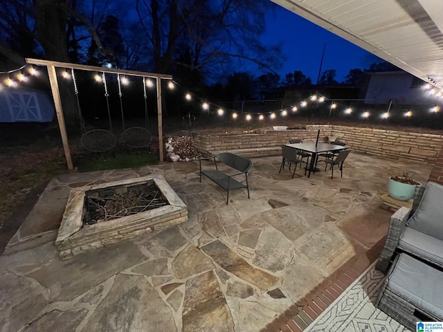 patio at twilight with outdoor dining area and fence