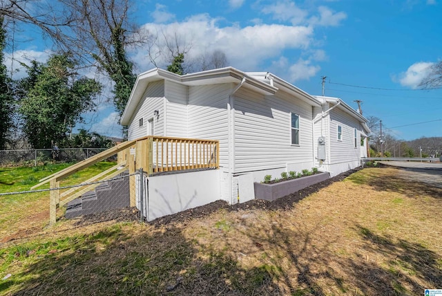 view of home's exterior with fence and a lawn