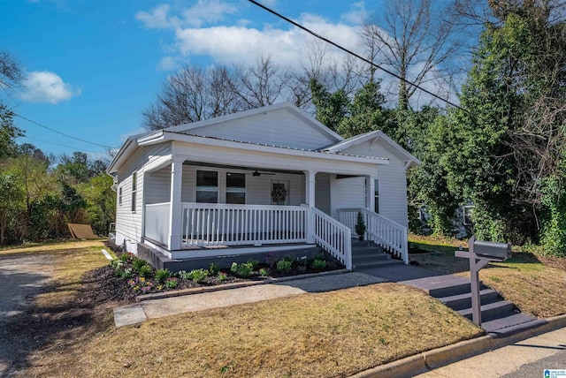 view of front facade featuring a front lawn, a ceiling fan, and covered porch