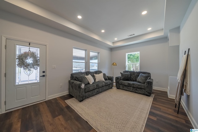 living area featuring visible vents, baseboards, dark wood finished floors, recessed lighting, and a raised ceiling