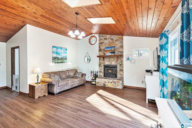 living room with vaulted ceiling with skylight, a stone fireplace, and wood finished floors