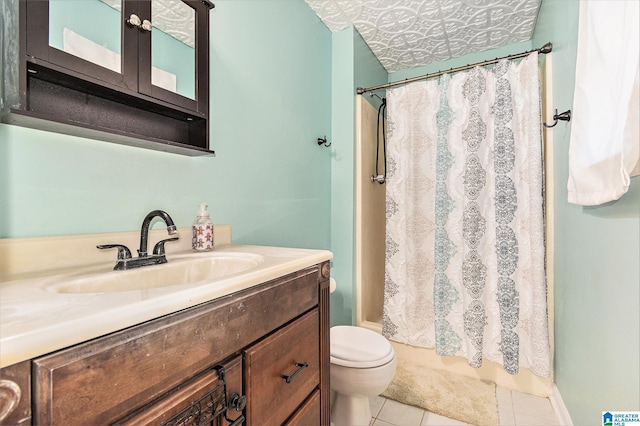 bathroom with curtained shower, toilet, vanity, and tile patterned flooring