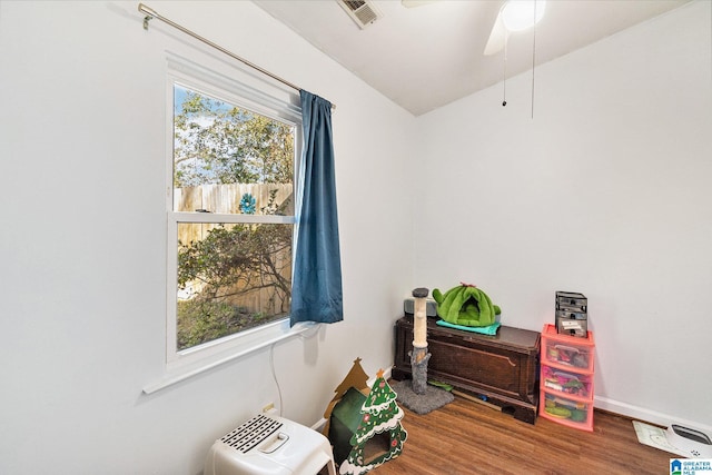 misc room with wood finished floors, a healthy amount of sunlight, visible vents, and baseboards