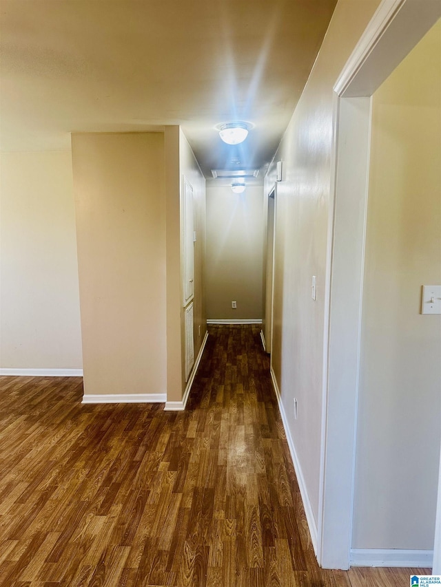hall featuring baseboards and dark wood-type flooring