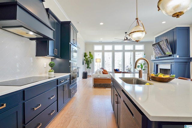 kitchen featuring ornamental molding, custom range hood, a sink, tasteful backsplash, and appliances with stainless steel finishes