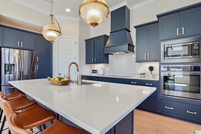 kitchen with a sink, stainless steel appliances, blue cabinetry, and custom exhaust hood