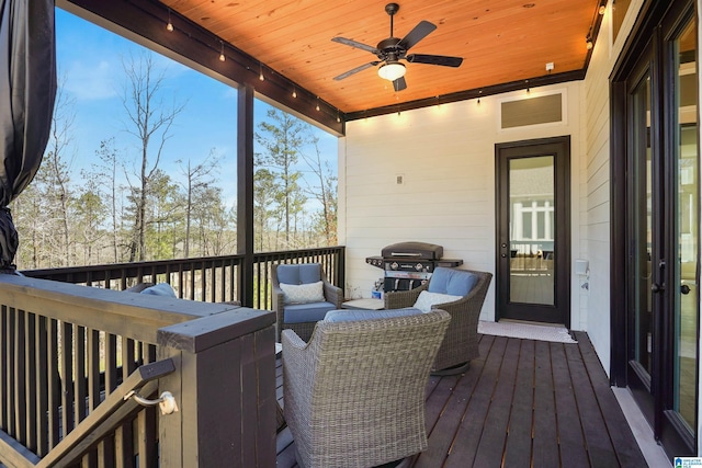 wooden terrace with area for grilling and a ceiling fan