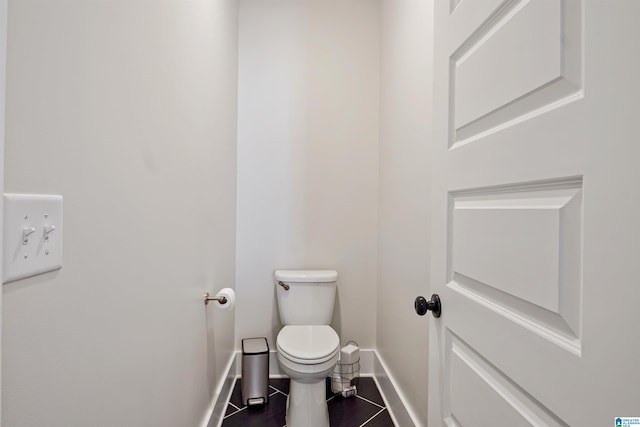 bathroom featuring baseboards, toilet, and wood finished floors