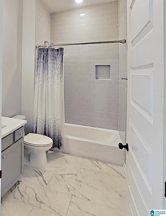 bathroom featuring marble finish floor, toilet, vanity, and shower / bathtub combination with curtain