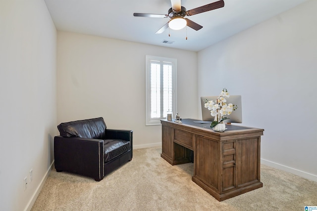 office space with baseboards, a ceiling fan, visible vents, and light carpet