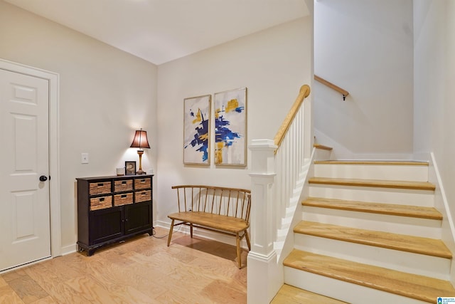 stairway featuring baseboards and wood finished floors