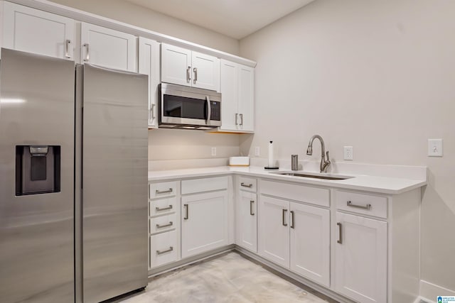 kitchen with a sink, light countertops, white cabinetry, and stainless steel appliances