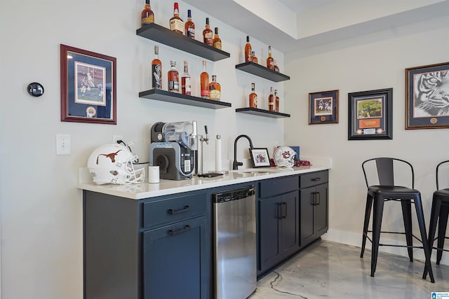 bar with indoor wet bar, refrigerator, baseboards, and a sink