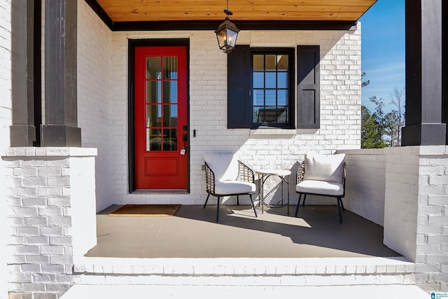 property entrance with brick siding and a porch