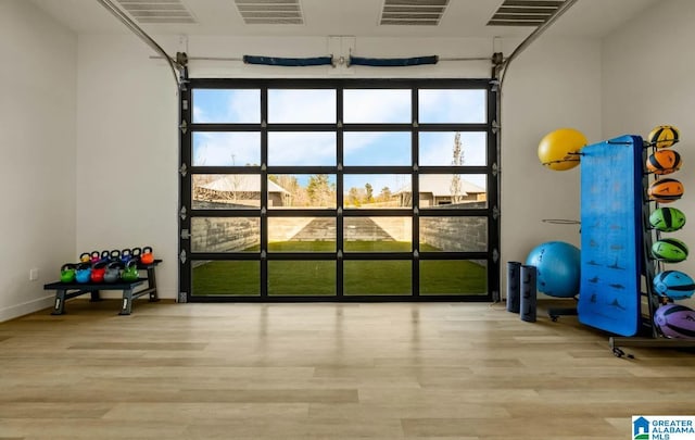 exercise room with light wood-type flooring, plenty of natural light, and visible vents