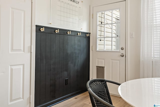 interior space with light wood finished floors and wood walls