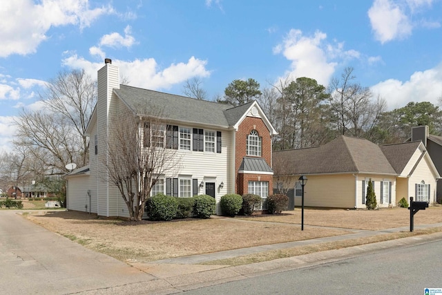 colonial inspired home featuring brick siding and a chimney