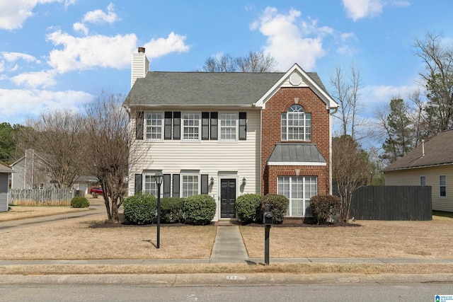 view of front of home featuring brick siding, a shingled roof, a chimney, and fence