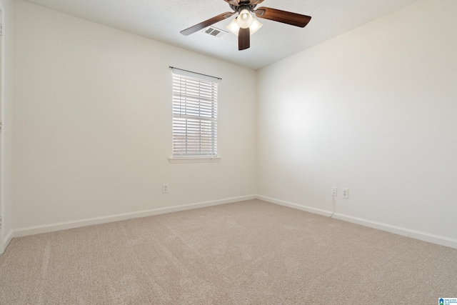 carpeted empty room with visible vents, baseboards, and ceiling fan