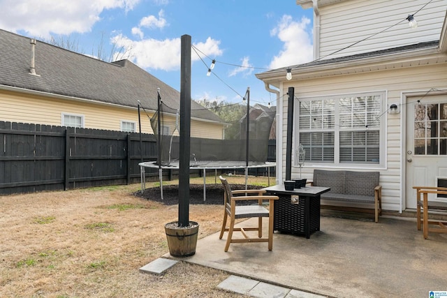 exterior space featuring a patio, a trampoline, and fence