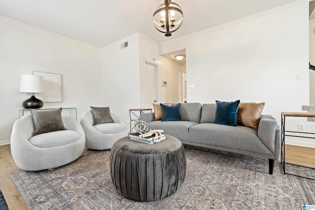 living room with baseboards, crown molding, an inviting chandelier, and wood finished floors