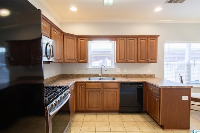 kitchen with brown cabinets, black appliances, ornamental molding, a sink, and a peninsula